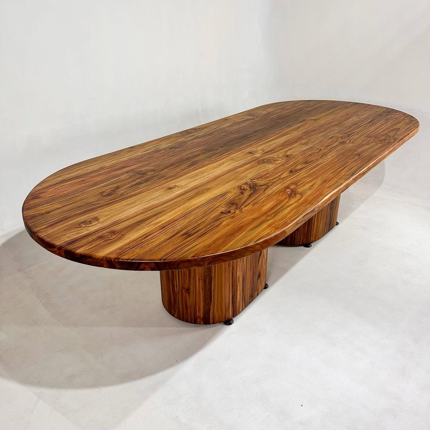 Mesa ovalada de madera maciza sobre pedestal